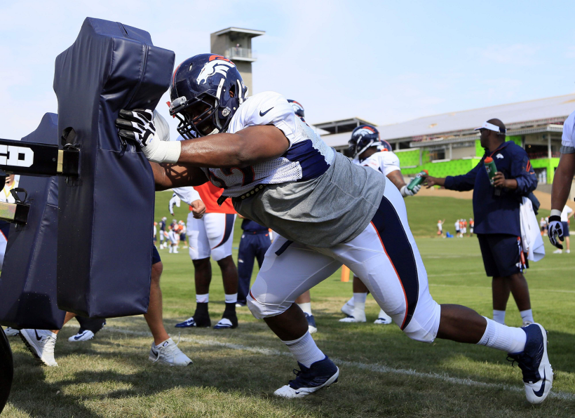 Nose Tackle Sylvester Williams hits a traditional football sled during the Denver Bronco's Training Camp.